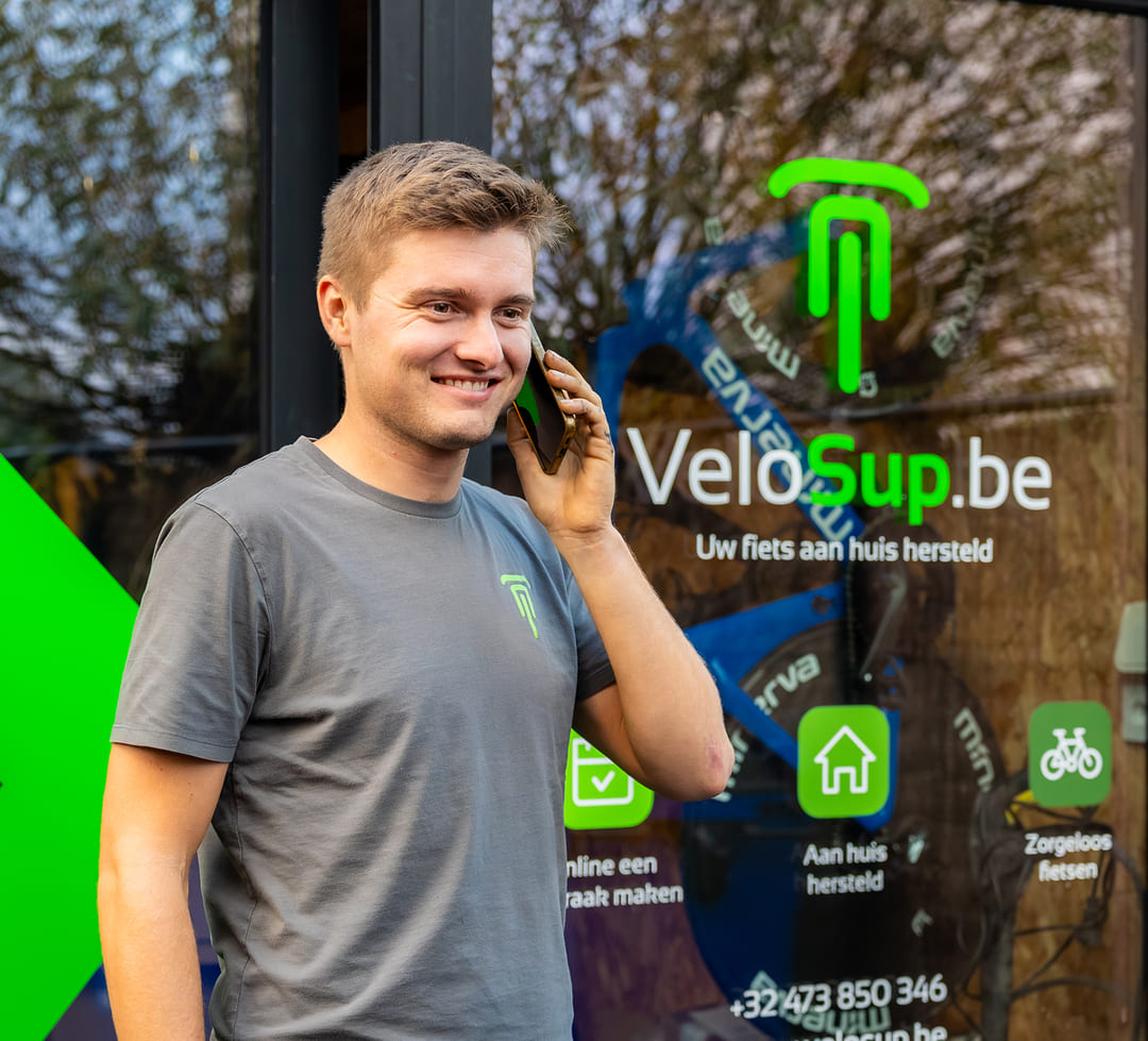 Fietsenmaker aan huis van VeloSup beantwoordt telefonisch klantenvragen over fietsherstellingen aan huis